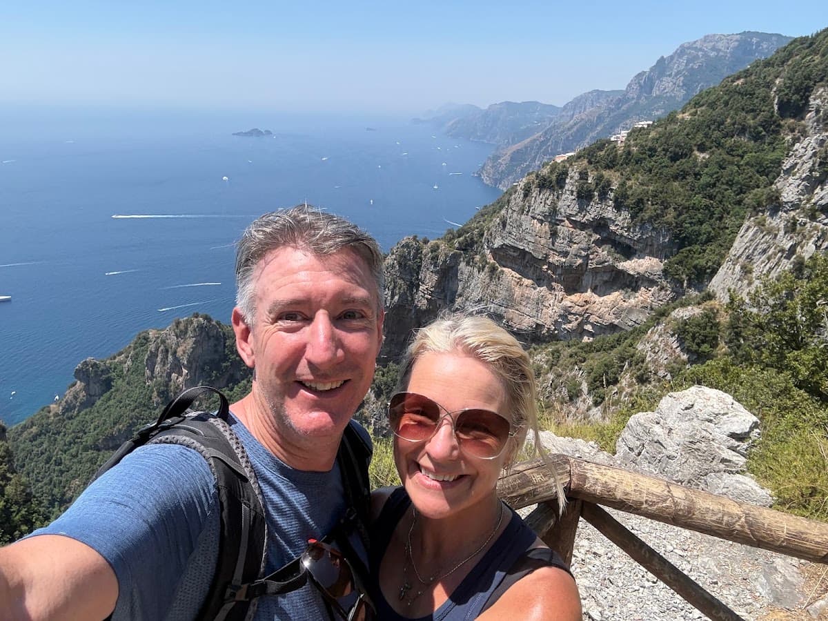 Hikers taking a selfie on coastal mountain trail overlooking the sea