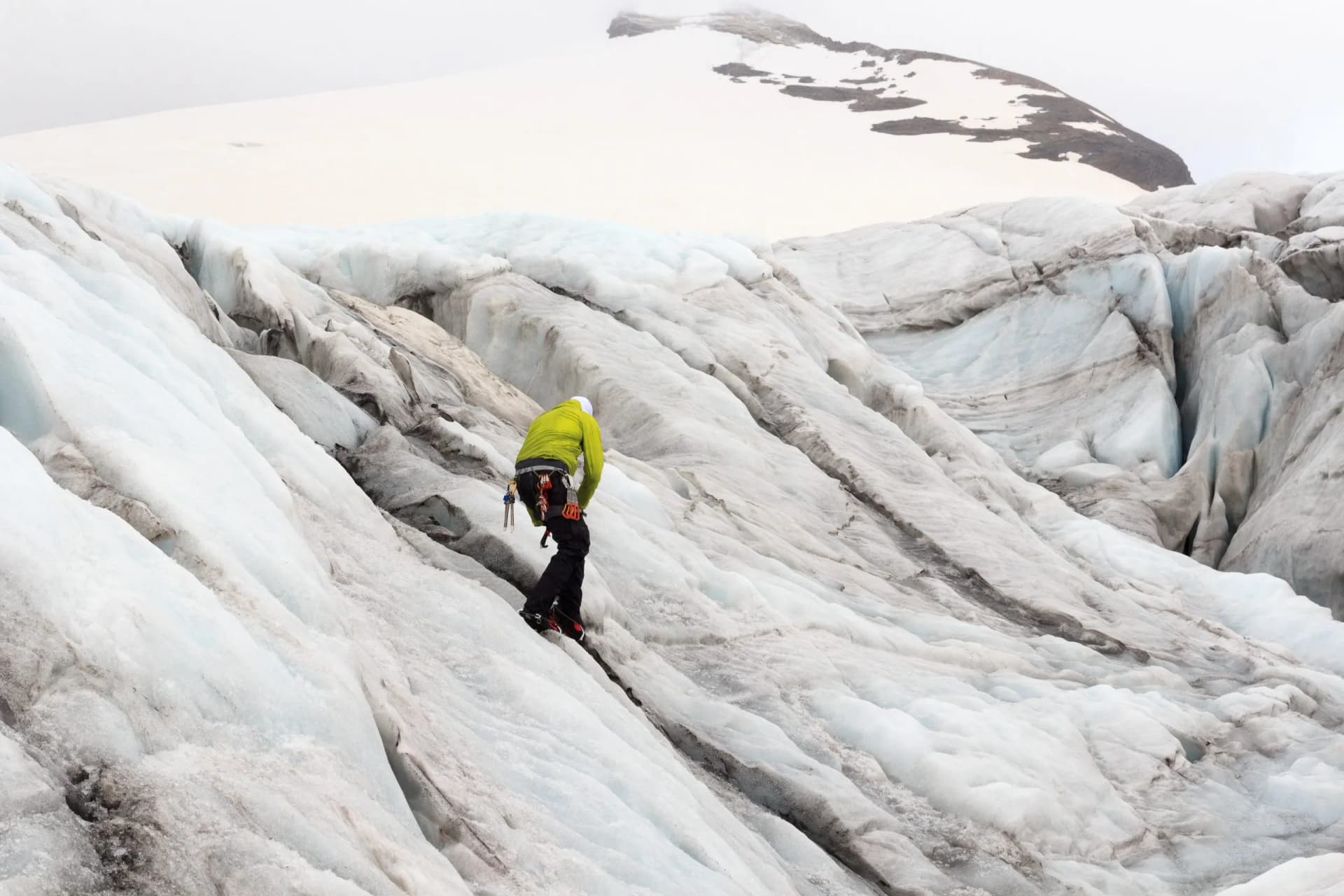 Man trains to mountaineer with crampons on glacier Pasterze in Glockner Group, Austria